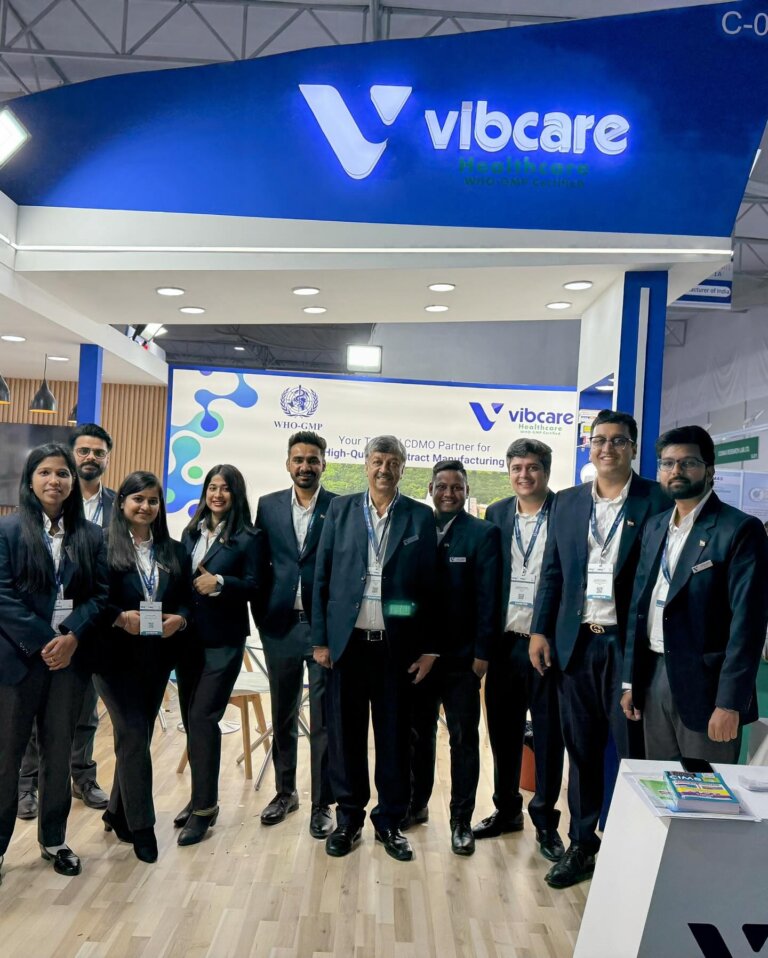 Vibcare Healthcare team beneath the stall signage at CPHI India 2024